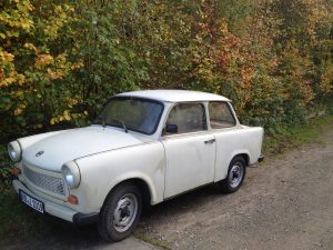Trabant parked next to a hedge
